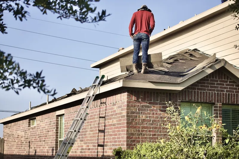 Professional roofer working on a residential roof in Roslindale